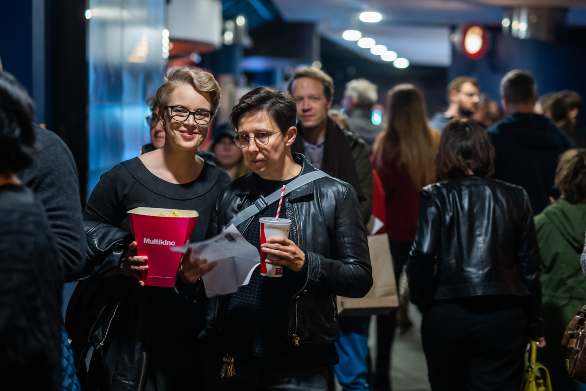 Publiznośc z popcornem przed salą kinową